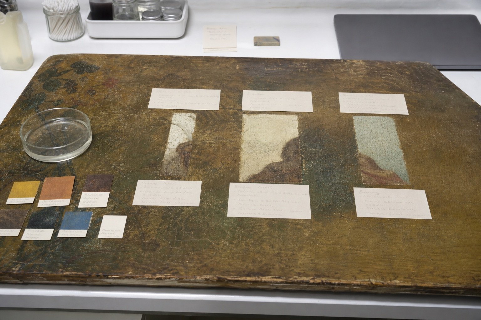 Conservation table used as a method board with three cleaned windows and a closed laptop